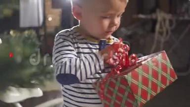 两岁的小男孩得到了一份礼物，礼物上有一根红丝带，<strong>还有</strong>一棵圣诞树，<strong>还有</strong>很多礼物盒